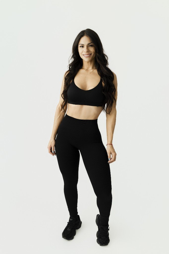 Alma, full-body studio portrait in black training kit
